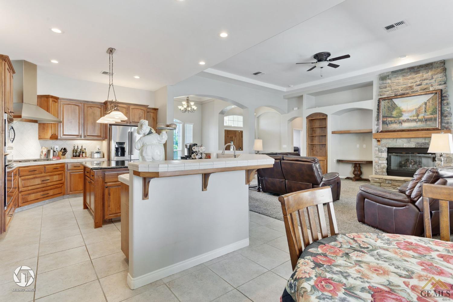 Undisclosed Address Bakersfield, CA 93313 - Photo 23 of 50 a kitchen with stainless steel appliances granite countertop a refrigerator a sink dishwasher a oven and a dining table with wooden floor