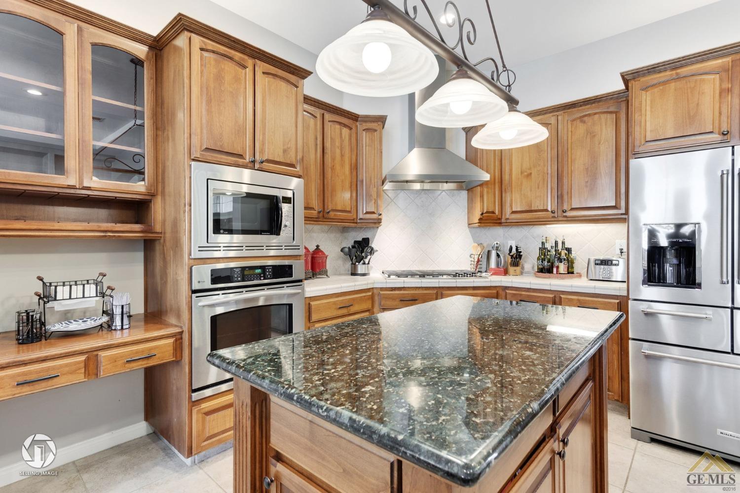 Undisclosed Address Bakersfield, CA 93313 - Photo 25 of 50 a kitchen with stainless steel appliances granite countertop a sink a stove and a microwave
