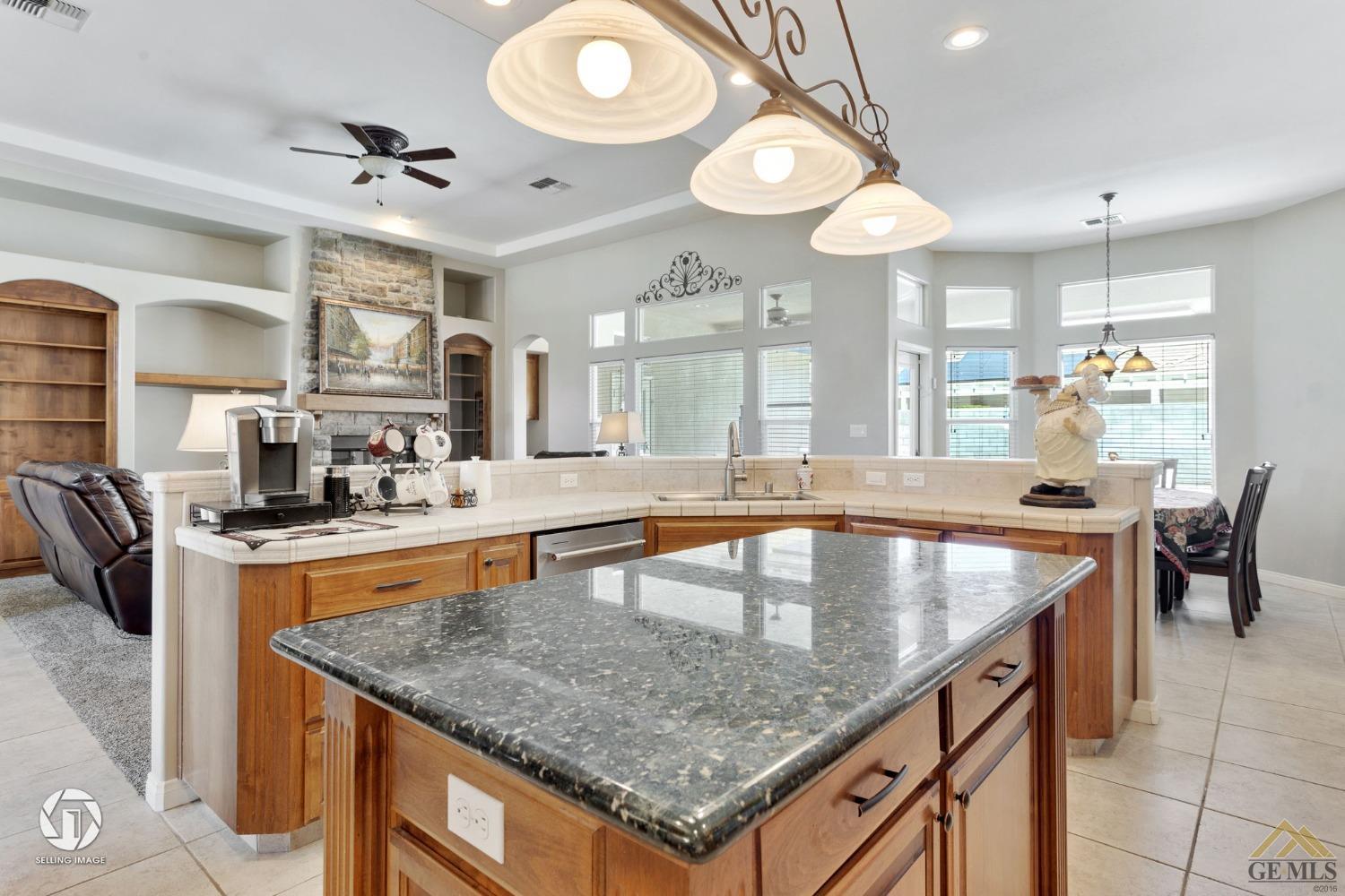 Undisclosed Address Bakersfield, CA 93313 - Photo 27 of 50 a kitchen with granite countertop a sink a counter top space and living room view
