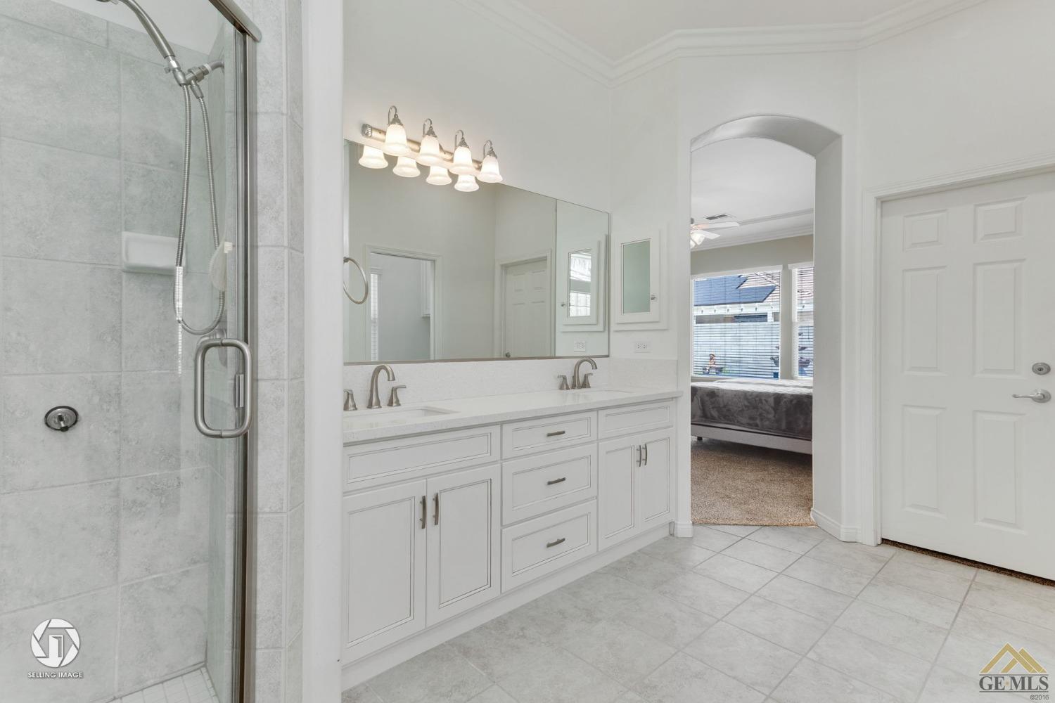 Undisclosed Address Bakersfield, CA 93313 - Photo 35 of 50 a spacious bathroom with a double vanity sink a large mirror and a shower