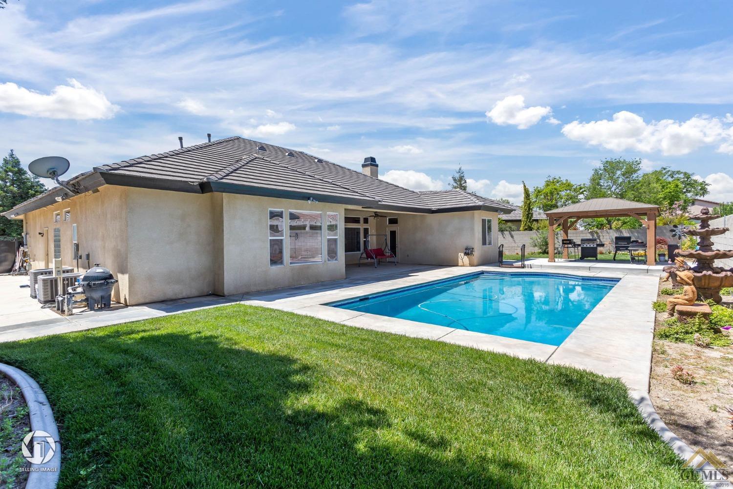 Undisclosed Address Bakersfield, CA 93313 - Photo 47 of 50 a view of a house with a swimming pool and a yard