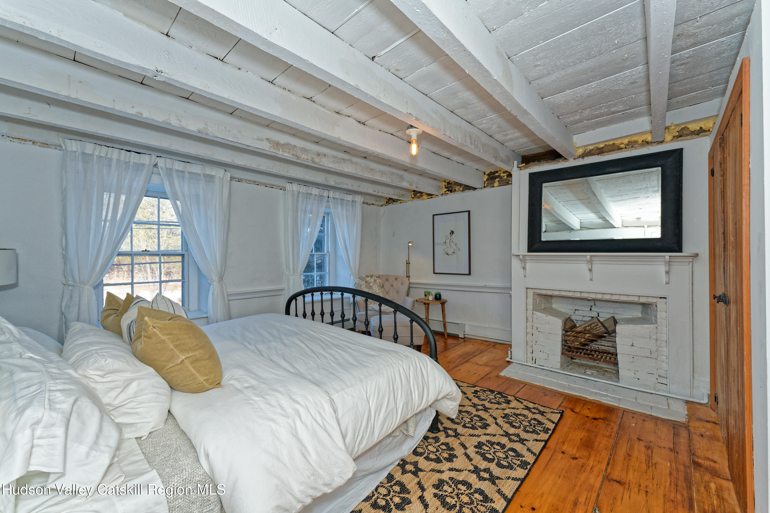 3953-3955 Highway 209 Stone Ridge, NY 12484 - Photo 17 of 69 a bedroom with a bed a mirror on the dresser and a flat screen tv