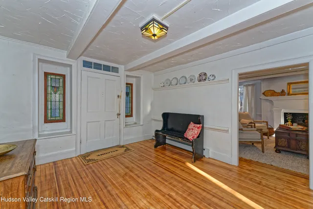 a view of a dining room with furniture a rug and wooden floor