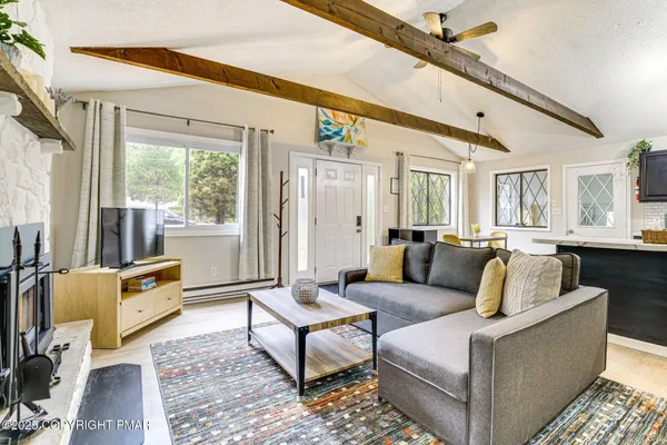 a living room with furniture wooden floor and a large window