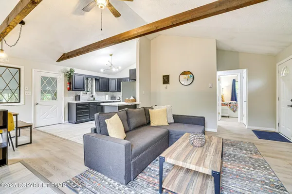 a living room with furniture kitchen view and a rug
