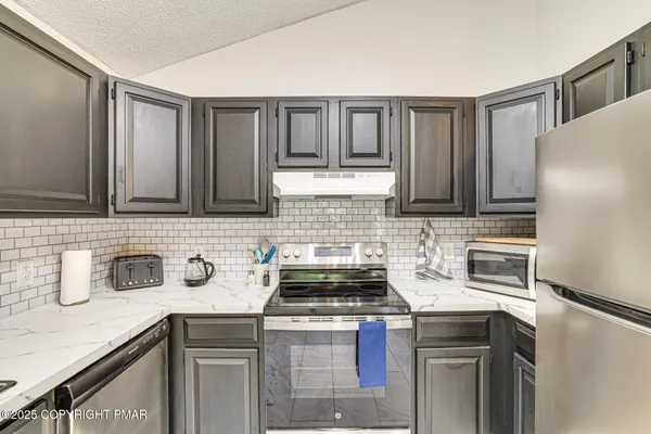 a kitchen with stainless steel appliances granite countertop a sink stove and cabinets