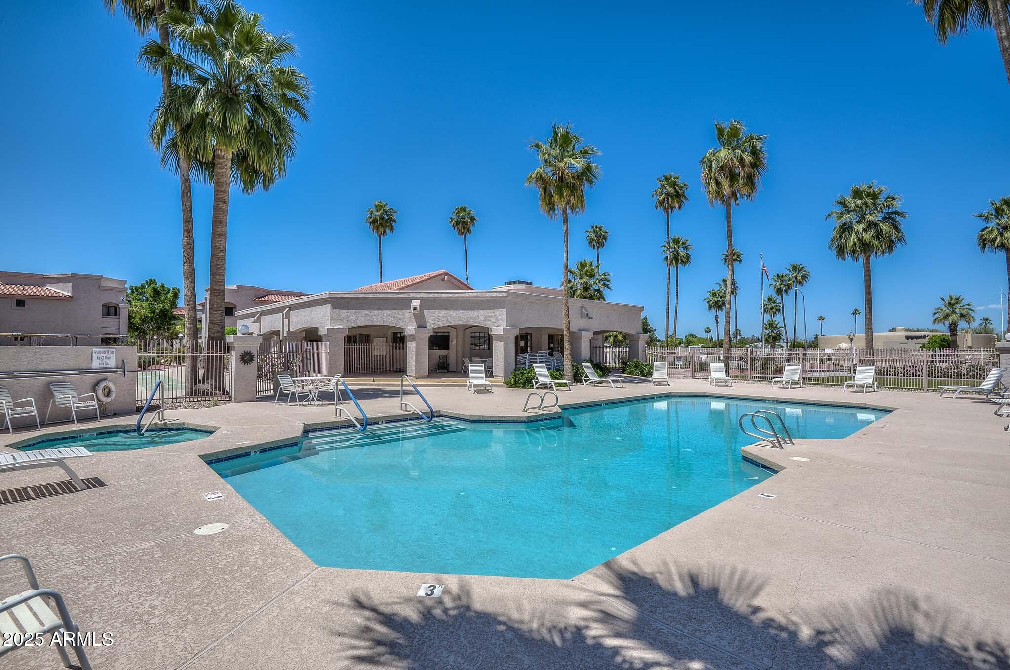 a view of a swimming pool with lawn chairs under an umbrella