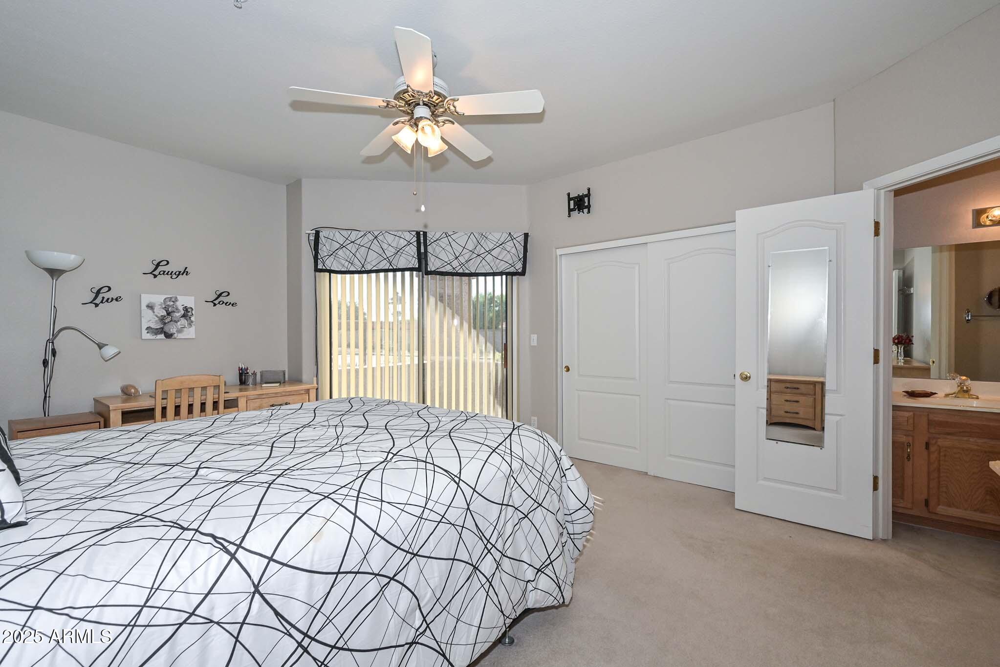 9151 West Greenway Road, Unit 113 Peoria, AZ 85381 - Photo 15 of 36 a bedroom with a large bed and a chandelier
