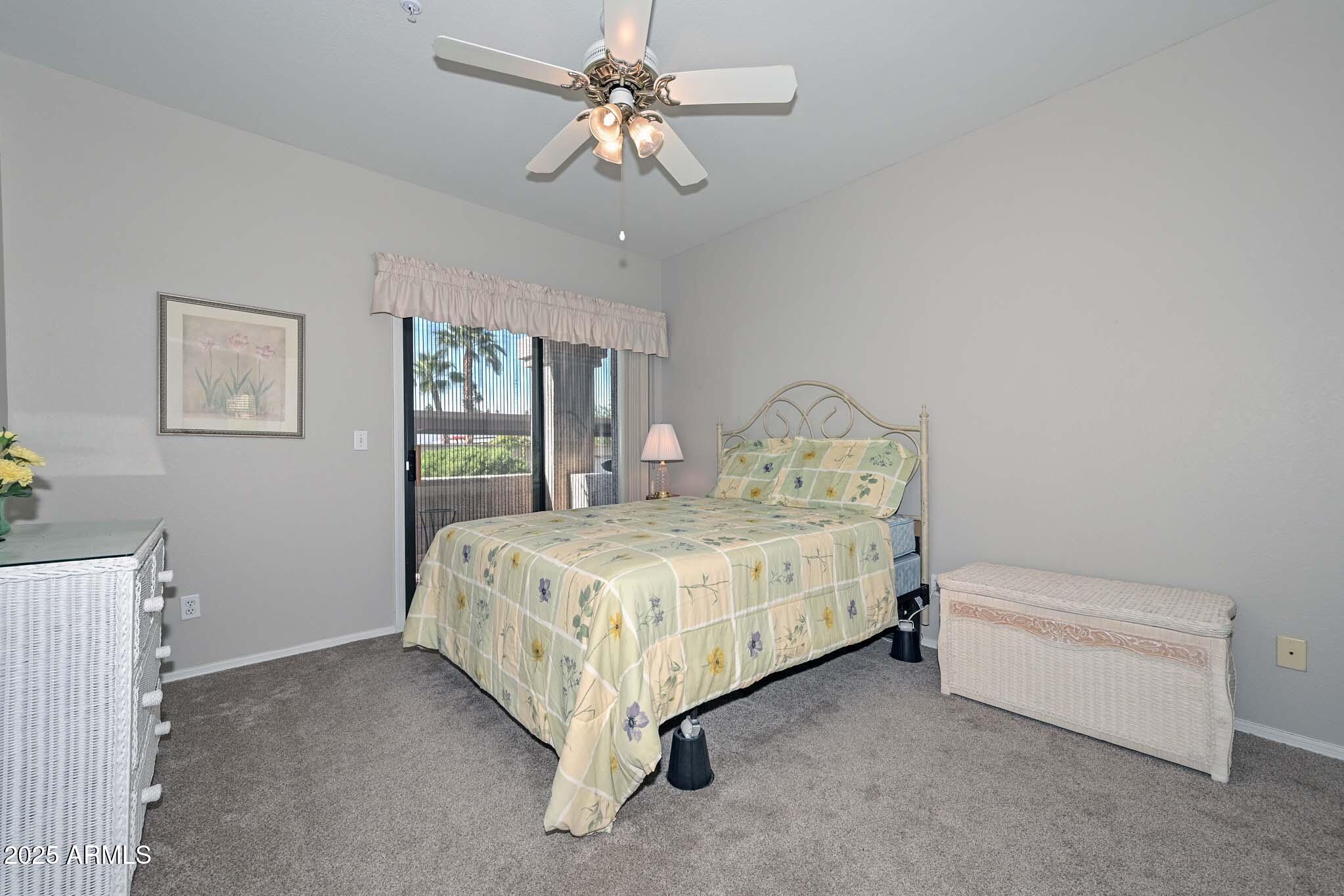 9151 West Greenway Road, Unit 113 Peoria, AZ 85381 - Photo 19 of 36 a bedroom with a bed chandelier and window