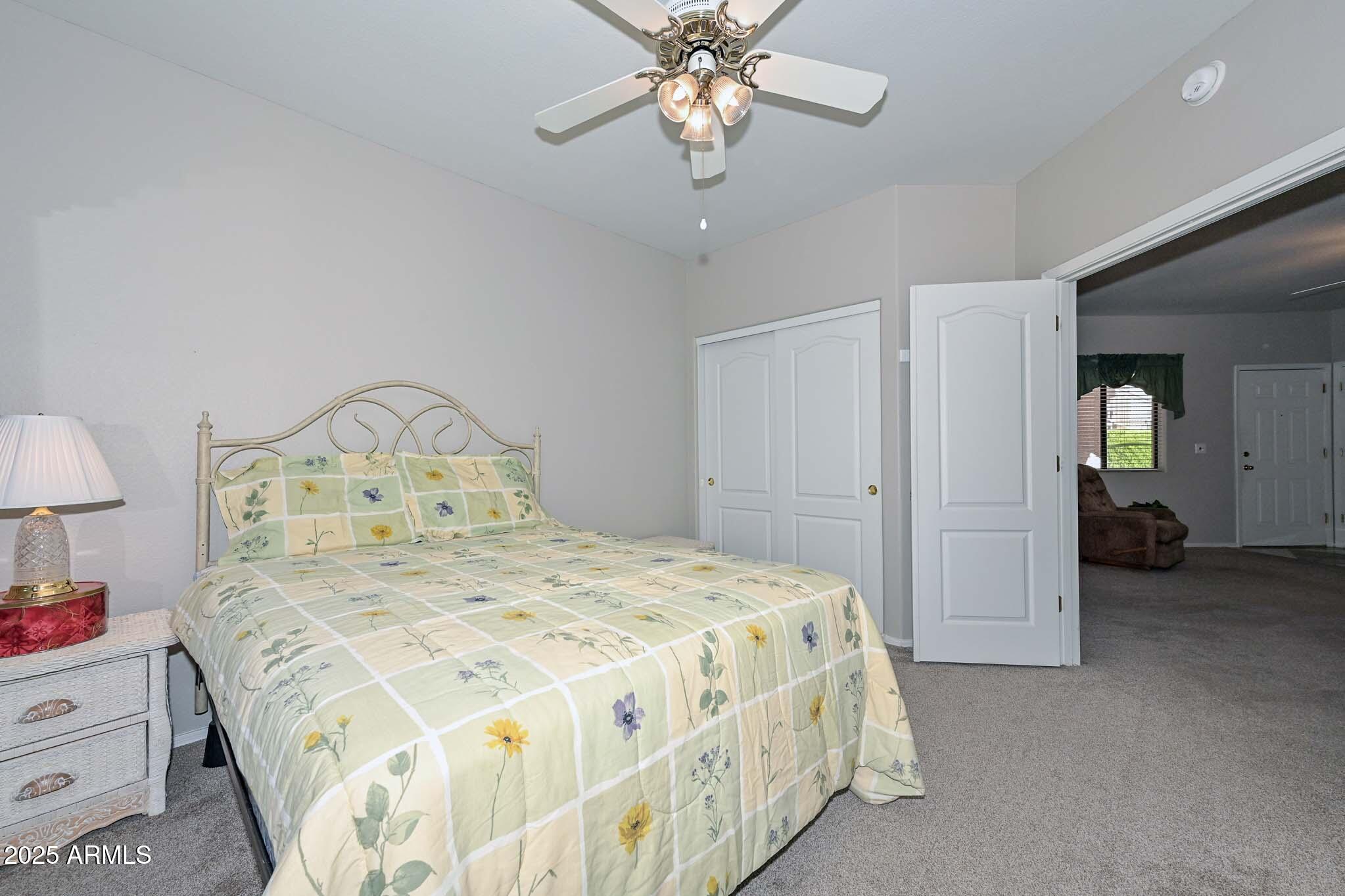 9151 West Greenway Road, Unit 113 Peoria, AZ 85381 - Photo 20 of 36 a bedroom with a bed and a chandelier