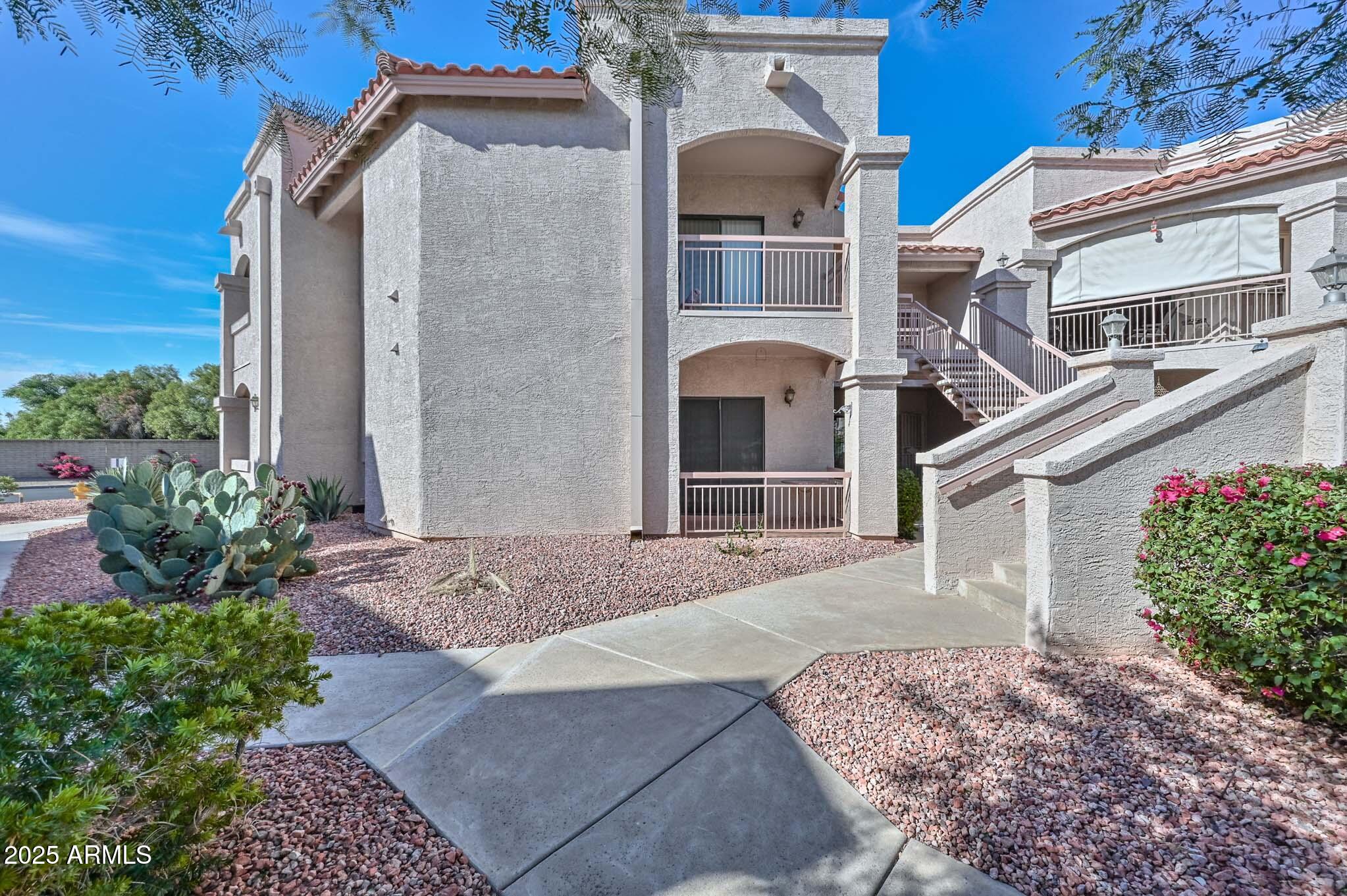 9151 West Greenway Road, Unit 113 Peoria, AZ 85381 - Photo 25 of 36 a front view of a house with garden