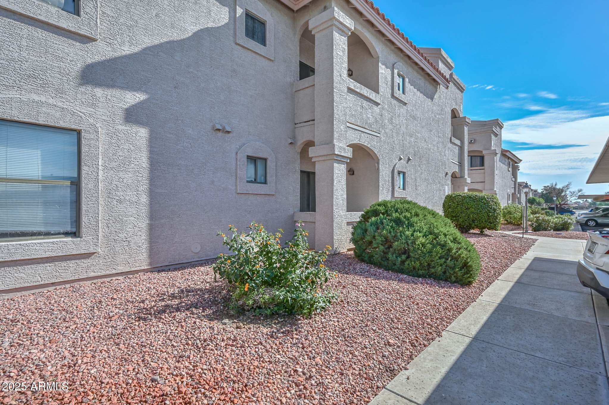 9151 West Greenway Road, Unit 113 Peoria, AZ 85381 - Photo 26 of 36 a front view of a house with garden