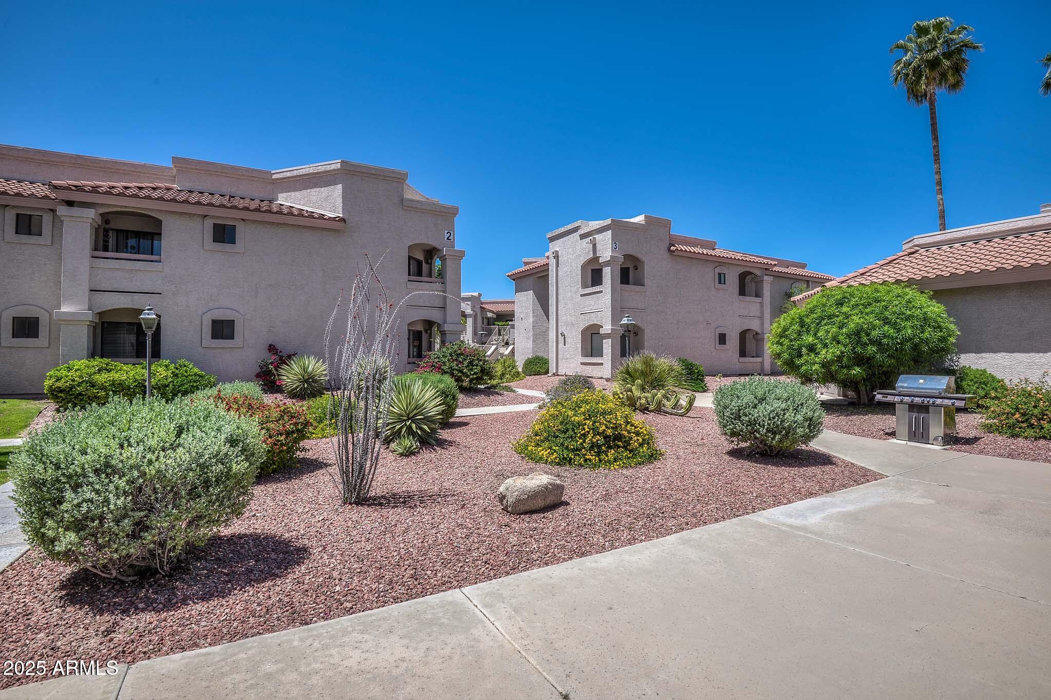 9151 West Greenway Road, Unit 113 Peoria, AZ 85381 - Photo 33 of 36 a front view of a house with a yard