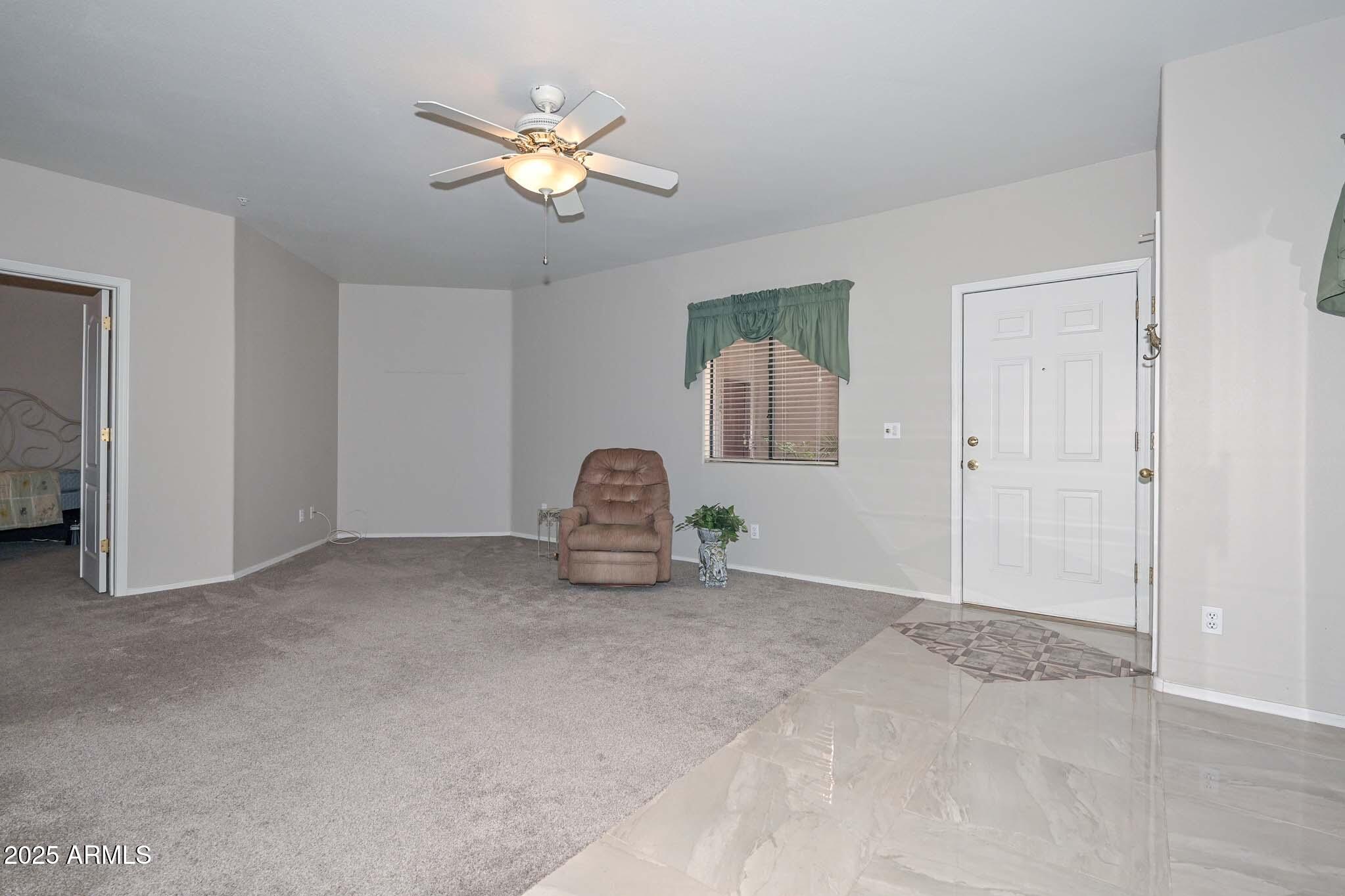 9151 West Greenway Road, Unit 113 Peoria, AZ 85381 - Photo 5 of 36 a view of a livingroom with a ceiling fan