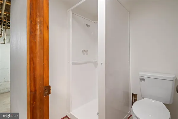 a white toilet sitting next to a shower