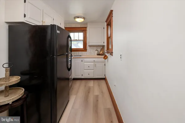 a kitchen with white cabinets and refrigerator