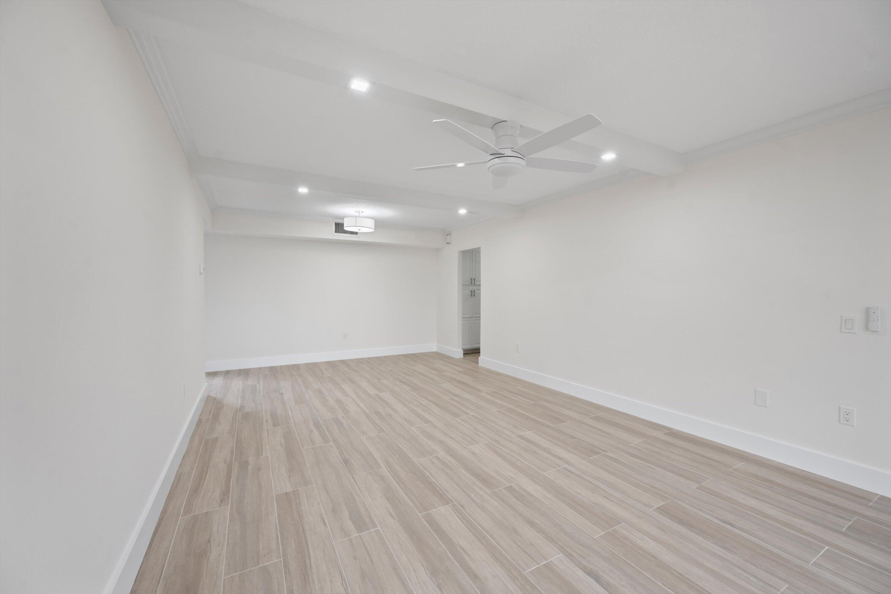 225 South Beach Road, Unit 102 Jupiter, FL 33469 - Photo 5 of 22 an empty room with wooden floor and windows