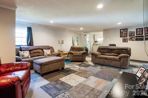 a living room with furniture and view of kitchen