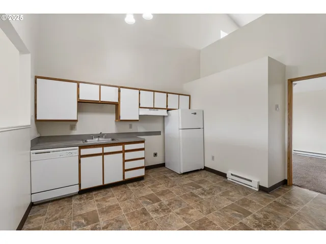 a kitchen with stainless steel appliances granite countertop a sink and a refrigerator