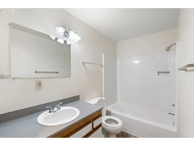 a bathroom with a sink a toilet a mirror and shower