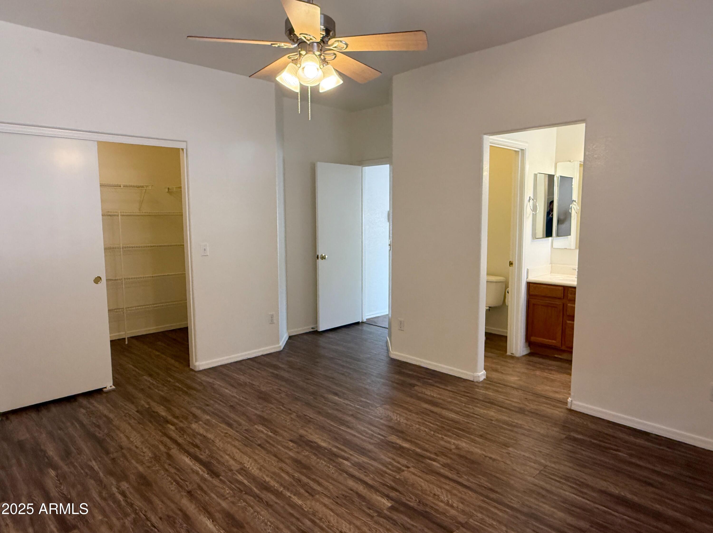2697 East Waterview Court Chandler, AZ 85249 - Photo 11 of 25 an empty room with wooden floor and a ceiling fan
