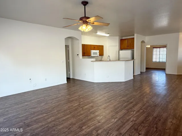 a view of a room with wooden floor and a ceiling fan