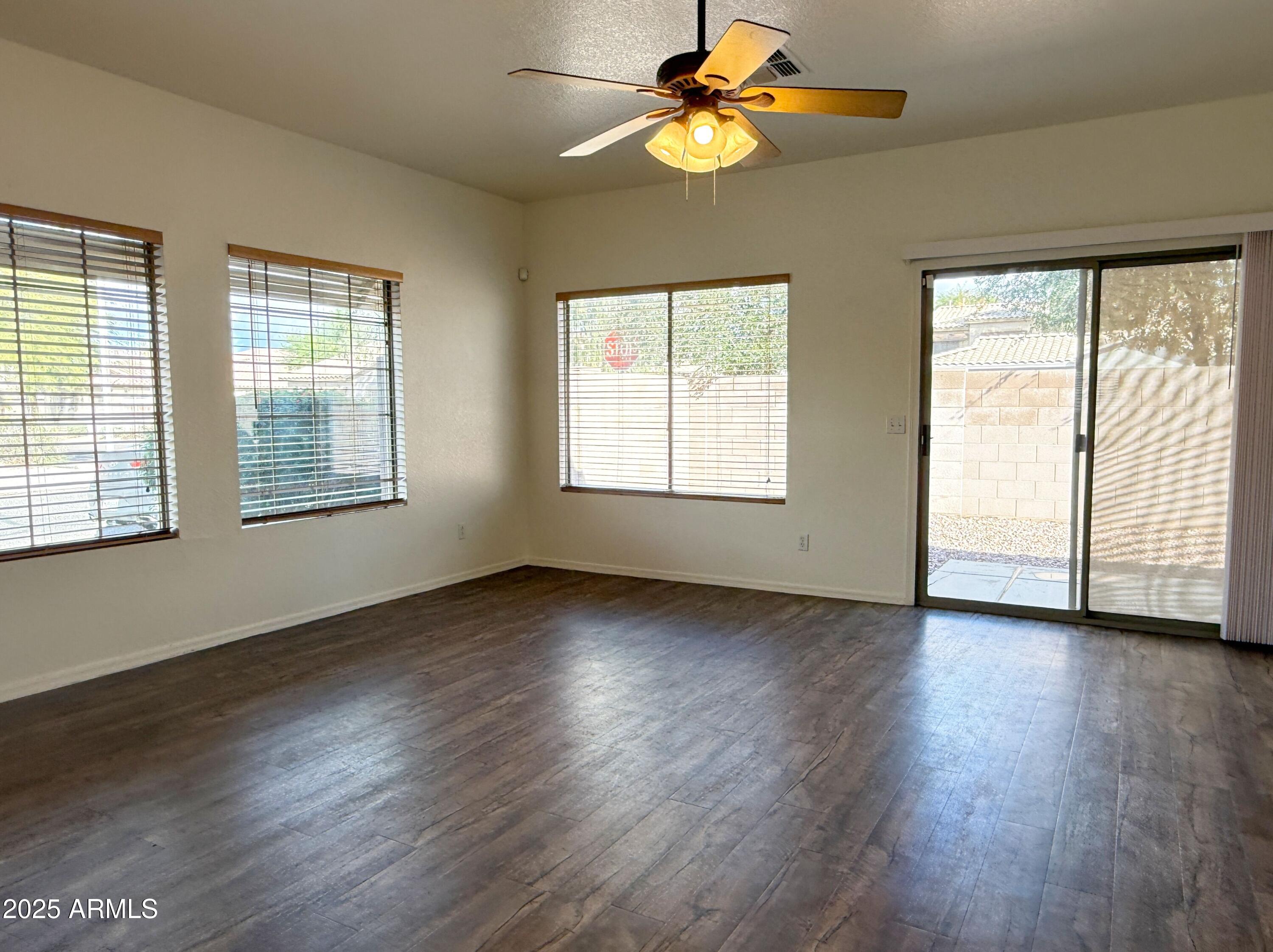 2697 East Waterview Court Chandler, AZ 85249 - Photo 7 of 25 a view of an empty room with wooden floor and a window