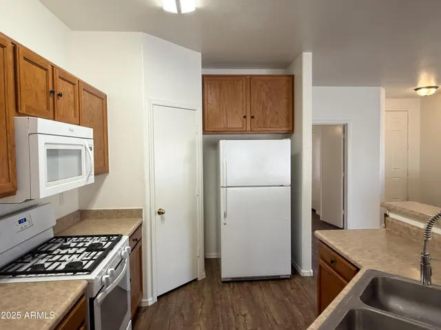 a kitchen with a refrigerator and a stove top oven