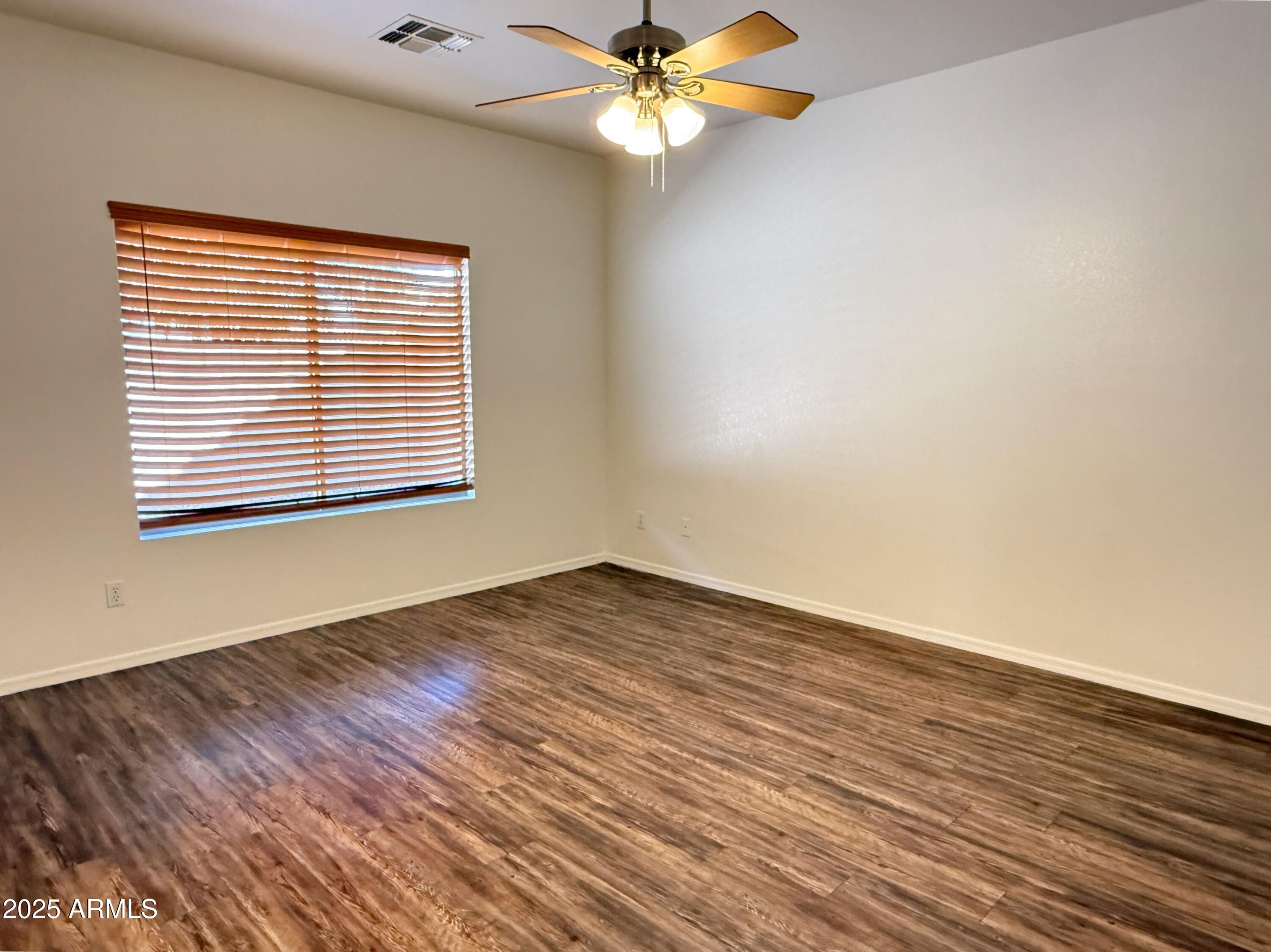 2697 East Waterview Court Chandler, AZ 85249 - Photo 10 of 25 a view of an empty room with wooden floor and a window
