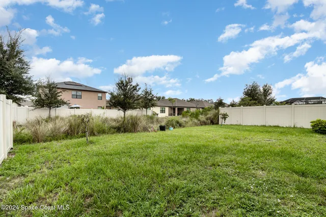a roof deck with table and chairs and potted plants