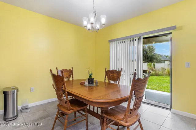 a kitchen with a sink a microwave a dining table and chairs