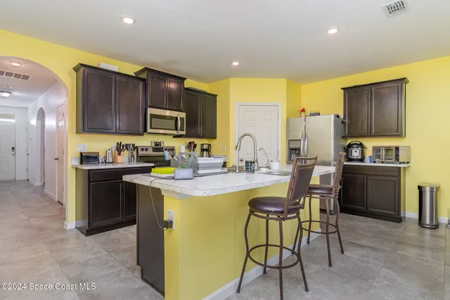 a kitchen with granite countertop stainless steel appliances a sink a stove and cabinets