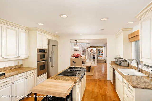 a kitchen with a refrigerator a sink and wooden cabinets