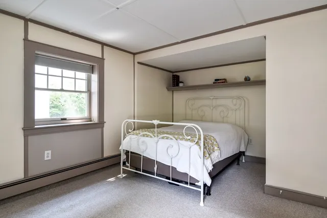 a bed sitting in a bedroom next to a window