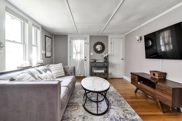 a living room with furniture a window and a flat screen tv