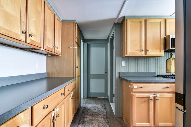 a kitchen with granite countertop cabinets stainless steel appliances and a window