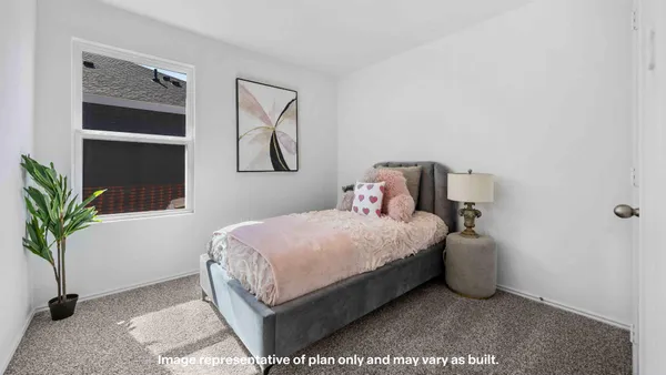 a bedroom with a bed and potted plant