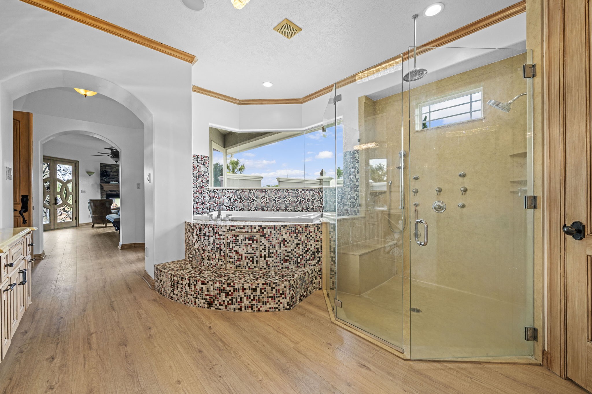 18732 Kz Road Cypress, TX 77433 - Photo 29 of 49 Luxury meets comfort in this primary bath, highlighting beautiful custom tile design around a deep soaking tub and a generous walk-in shower with a built-in seat.