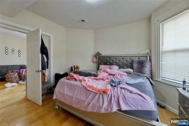 a bedroom with a bed and wooden floor