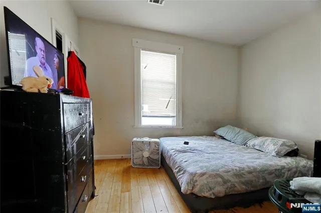 a bedroom with a bed and wooden floor