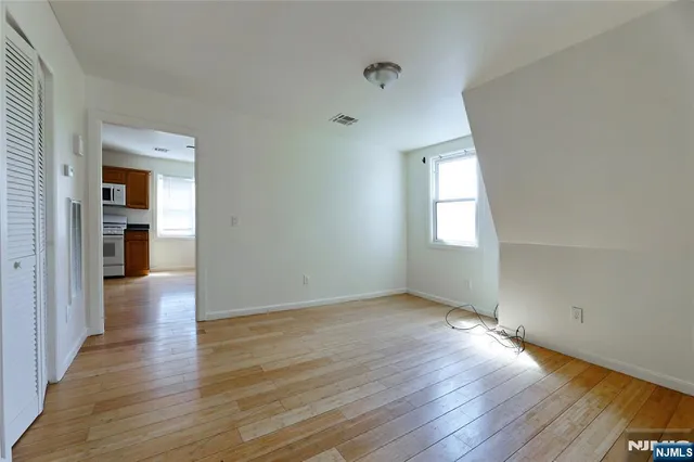 an empty room with wooden floor and a window