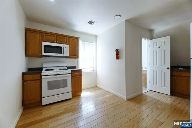 a kitchen with granite countertop a stove and a microwave