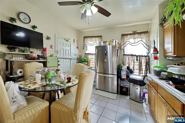 a kitchen with stainless steel appliances a stove a refrigerator a dining table and chairs