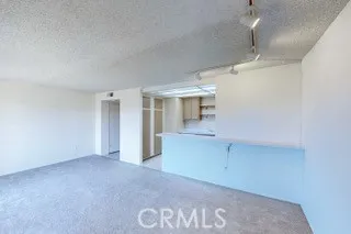 an empty room with chandelier fan and windows