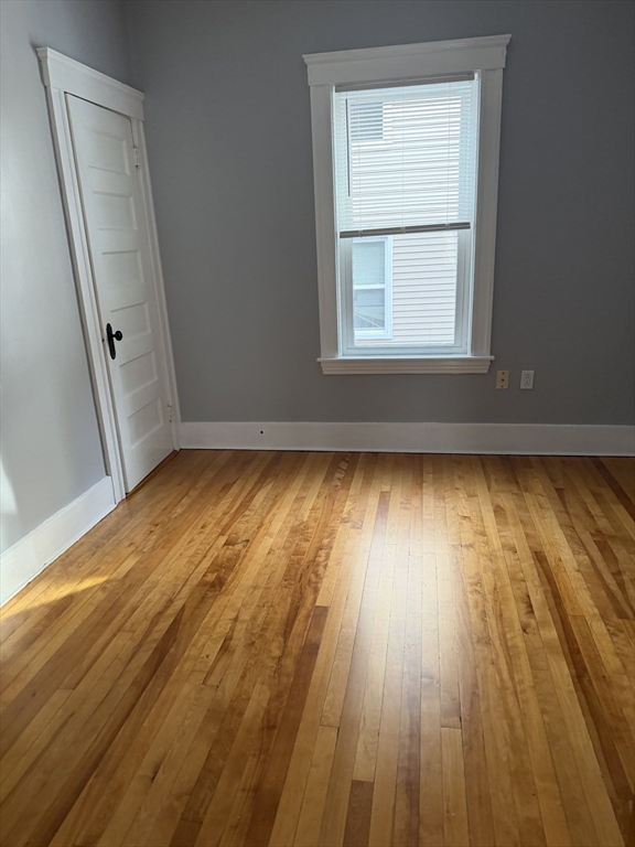 29 Boardman Street, Unit 2 Worcester, MA 01606 - Photo 11 of 16 an empty room with wooden floor and windows