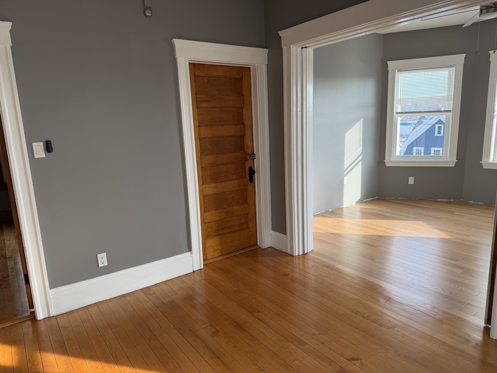29 Boardman Street, Unit 2 Worcester, MA 01606 - Photo 7 of 16 an empty room with wooden floor and windows