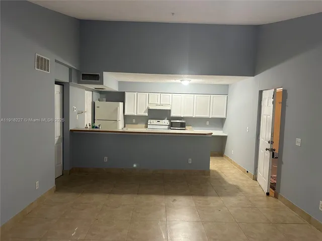 a kitchen with stainless steel appliances a refrigerator and a cabinets