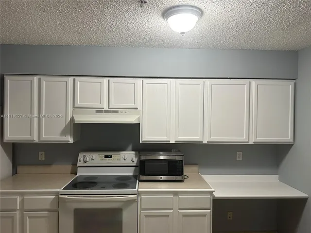 a kitchen with white cabinets and white appliances