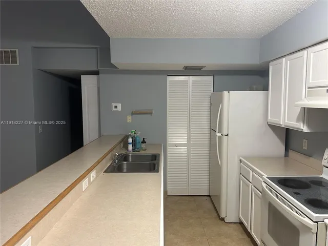 a kitchen with a refrigerator and a sink