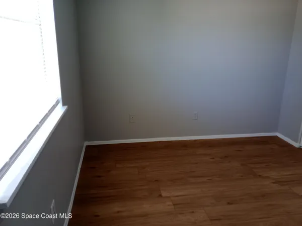 a view of a small space with wooden floor and a window